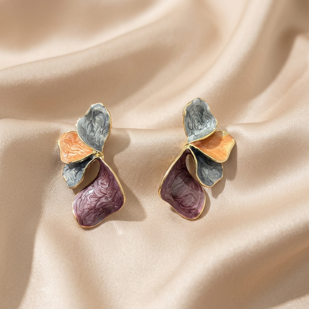 A pair of gold-tone butterfly earrings with textured enamel wings in muted gray, peach, and mauve-purple.