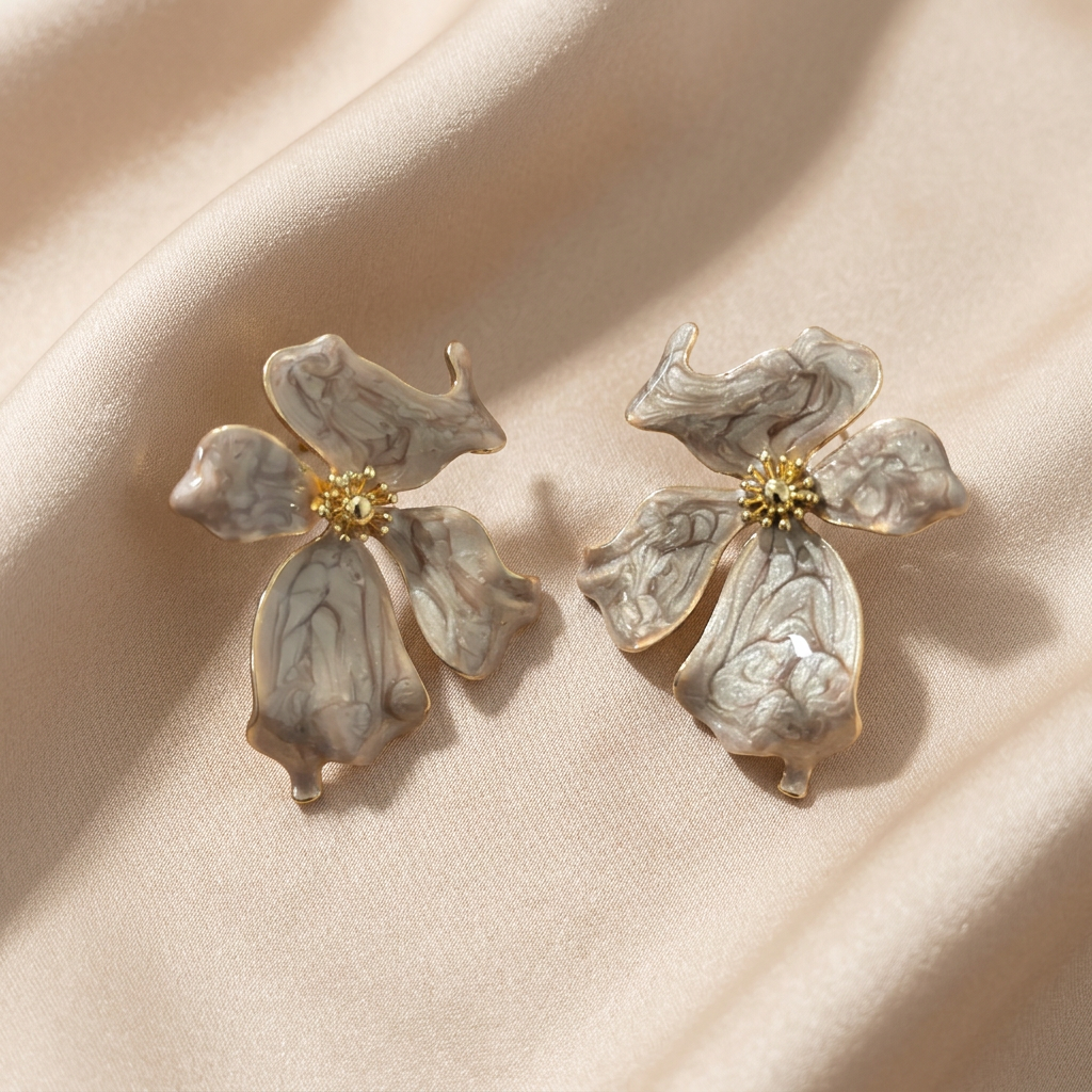 A pair of vintage-style flower-shaped earrings with marbled off-white petals and gold centers.
