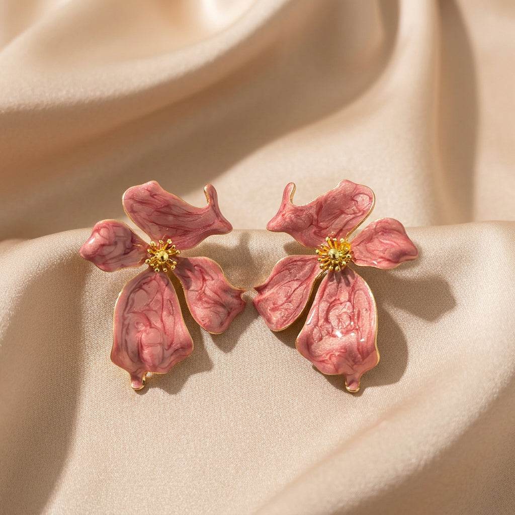 A pair of pink dogwood flower stud earrings with gold centers.