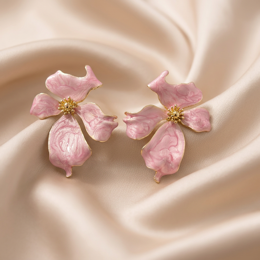 A pair of pink and white marbled flower-shaped earrings with gold centers.