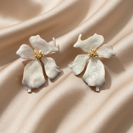 A pair of white dogwood flower stud earrings with gold centers.