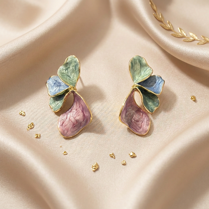 A pair of gold-tone butterfly earrings with textured pastel green wings and pink lower wings.